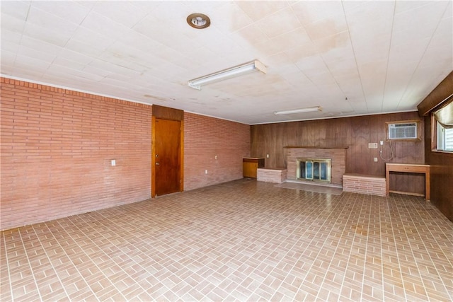 1325 S Whitney St, Aransas Pass, TX 78336 - interior space featuring brick wall, an AC wall unit, a glass covered fireplace, wooden walls, and brick patterned floor