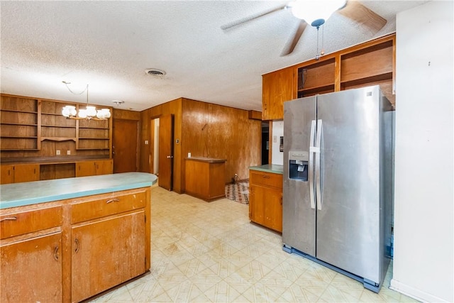 1325 S Whitney St, Aransas Pass, TX 78336 - kitchen with light floors, open shelves, stainless steel fridge, brown cabinets, and a textured ceiling