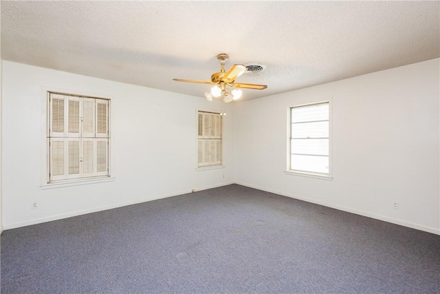 1325 S Whitney St, Aransas Pass, TX 78336 - unfurnished room with baseboards, dark carpet, a ceiling fan, and a textured ceiling