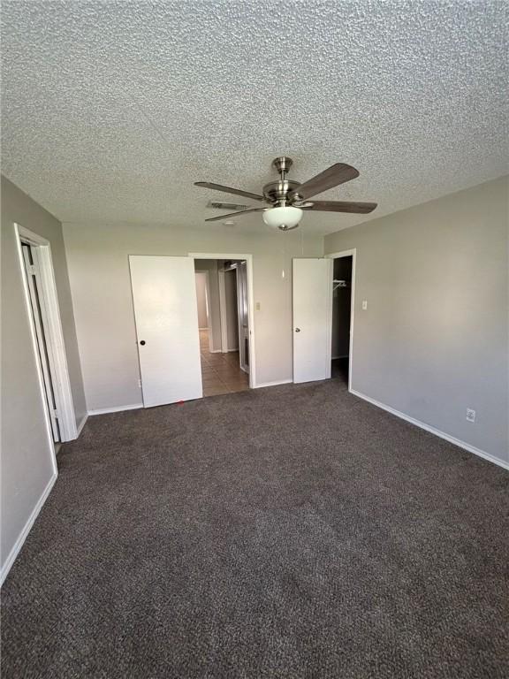 4401 River Valley Dr Unit 503, Corpus Christi, TX 78410 - unfurnished bedroom with dark carpet, a textured ceiling, and ceiling fan