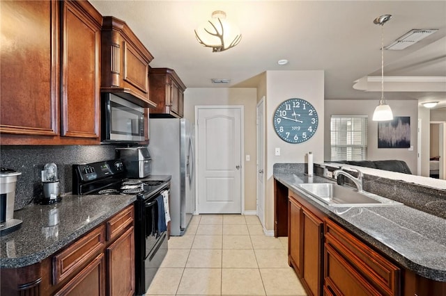 kitchen with appliances with stainless steel finishes, sink, light tile patterned floors, a kitchen island, and hanging light fixtures