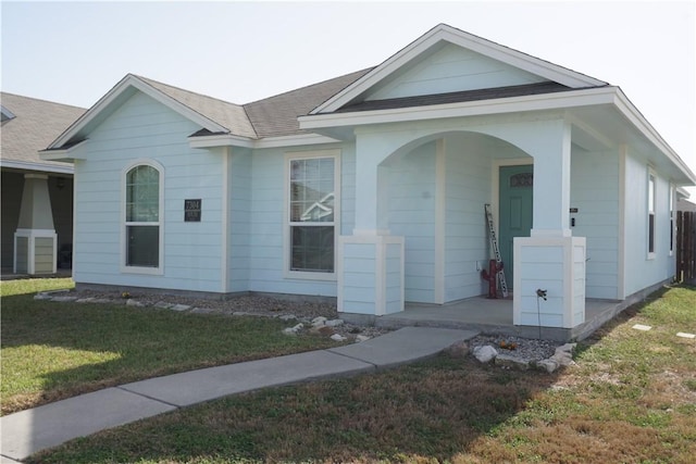 single story home featuring a front yard and roof with shingles