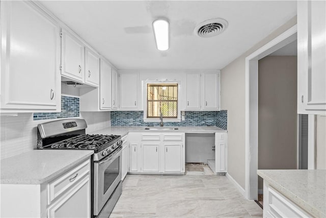 5611 Nelson, Corpus Christi, TX 78411 - kitchen with stainless steel range with gas cooktop, white cabinets, decorative backsplash, and light marble finish flooring