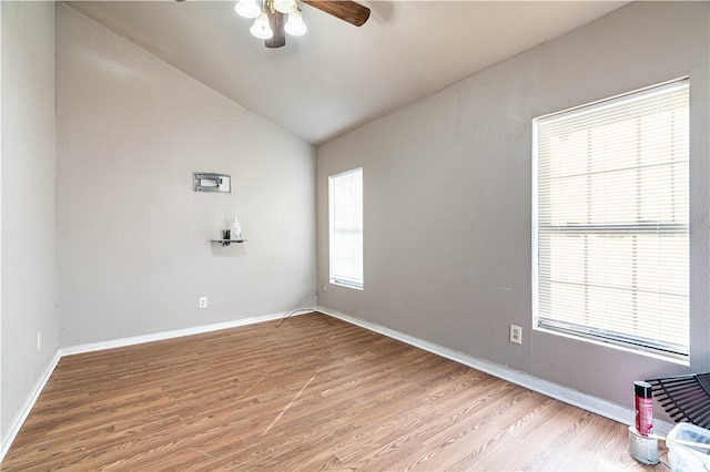 empty room featuring plenty of natural light, light hardwood / wood-style floors, and vaulted ceiling