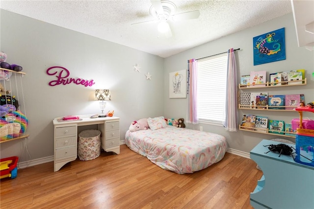 bedroom featuring light wood-type flooring, a textured ceiling, and ceiling fan