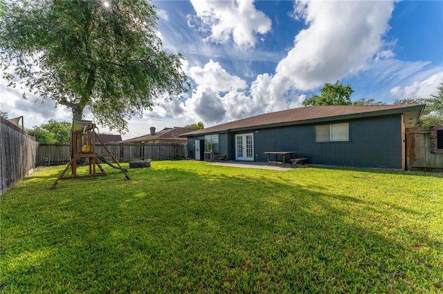 view of yard featuring a patio, a playground, and french doors