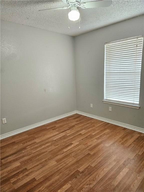 unfurnished room with ceiling fan, hardwood / wood-style floors, and a textured ceiling