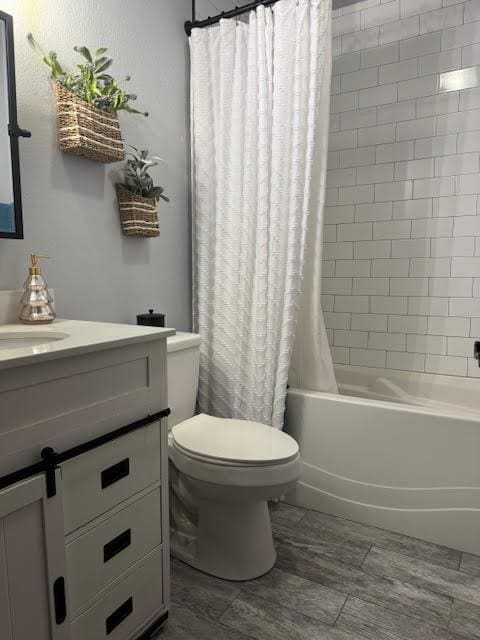 full bathroom with wood-type flooring, toilet, shower / bathtub combination with curtain, and vanity