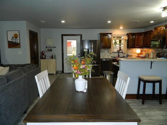 dining room with sink and light wood-type flooring