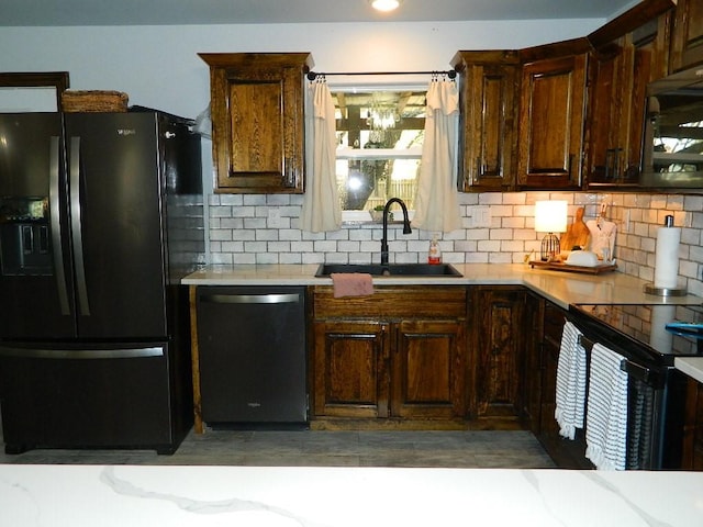 kitchen featuring sink, backsplash, and black appliances