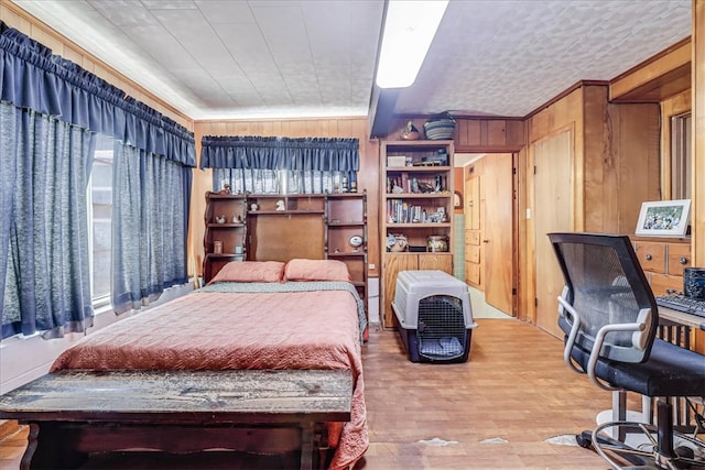 bedroom featuring hardwood / wood-style floors and wooden walls