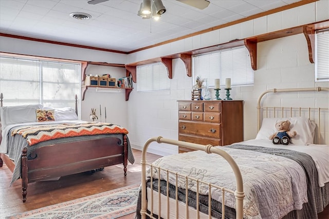 bedroom with ornamental molding, wood-type flooring, and ceiling fan