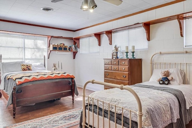 195 Carmel Dr, Sandia, TX 78383 - bedroom with wood finished floors, ornamental molding, concrete block wall, and ceiling fan