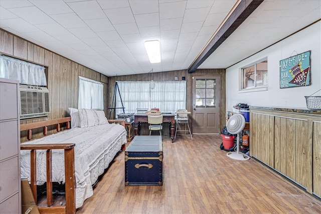 bedroom featuring wood walls, wood-type flooring, and lofted ceiling