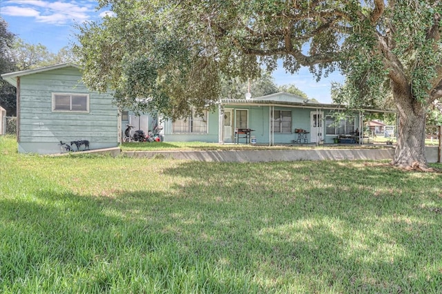 rear view of house featuring a lawn and covered porch