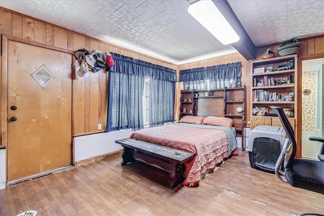 bedroom featuring wooden walls and wood-type flooring