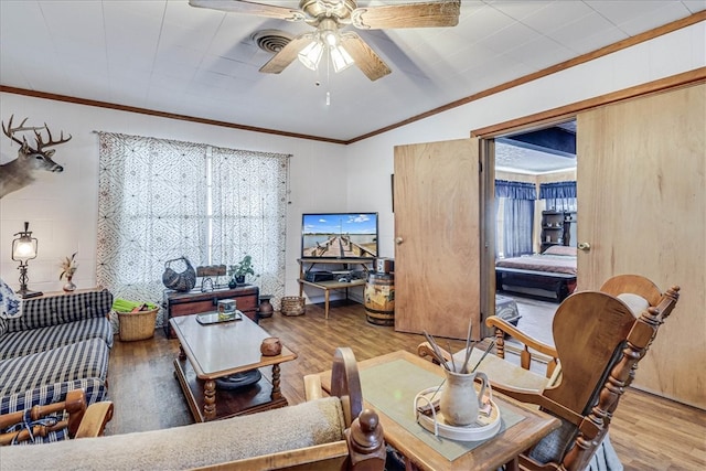 living room featuring ornamental molding, hardwood / wood-style flooring, and ceiling fan