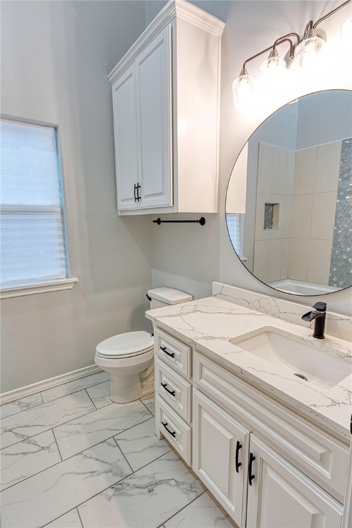 bathroom with a shower, vanity, and toilet