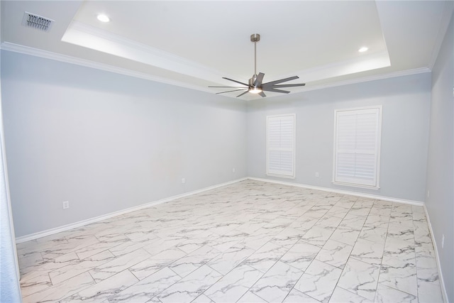 spare room with ceiling fan, ornamental molding, and a tray ceiling