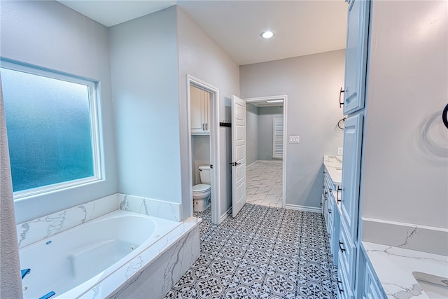 bathroom with a relaxing tiled tub, toilet, and vanity