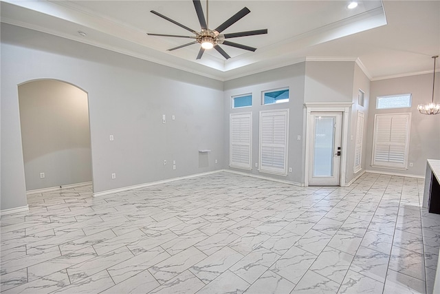 unfurnished room featuring ceiling fan with notable chandelier, a tray ceiling, and ornamental molding