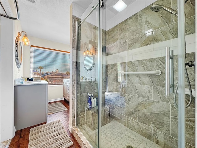 full bathroom featuring a shower stall and wood finished floors