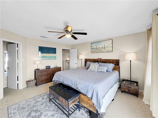 bedroom with visible vents, baseboards, a ceiling fan, carpet, and a textured ceiling