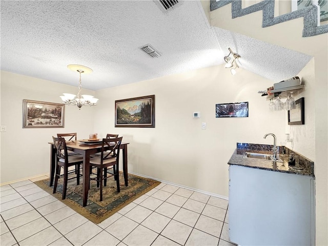 dining room featuring a textured ceiling, light tile patterned flooring, and visible vents