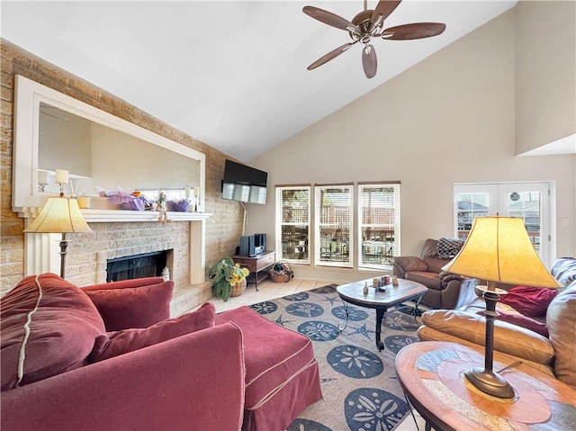 living area with high vaulted ceiling, tile patterned flooring, a brick fireplace, and a ceiling fan