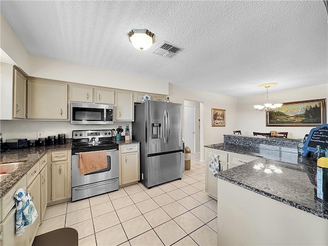 kitchen with visible vents, a chandelier, a textured ceiling, cream cabinetry, and stainless steel appliances