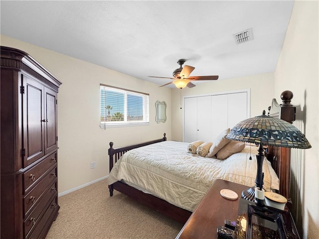 bedroom with visible vents, baseboards, a closet, ceiling fan, and light colored carpet