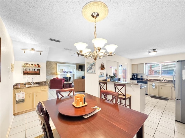 dining space featuring light tile patterned floors, a chandelier, visible vents, and a textured ceiling