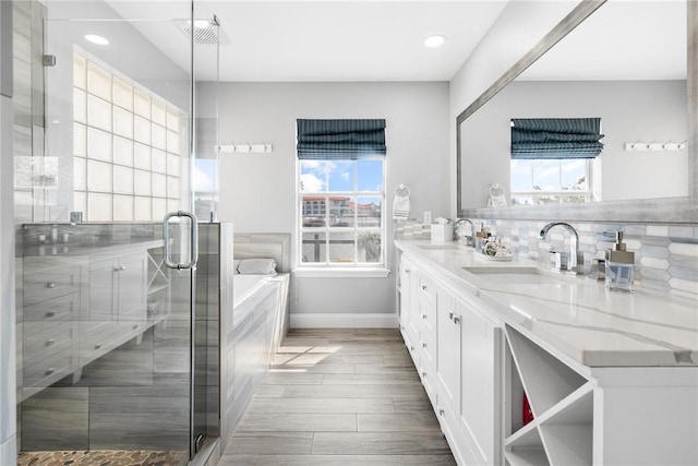 bathroom featuring double vanity, a stall shower, tasteful backsplash, and a sink