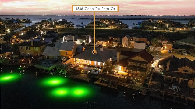 aerial view at dusk featuring a water view