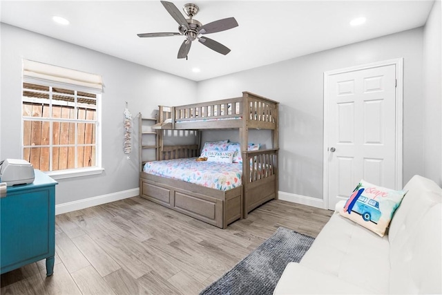 bedroom featuring baseboards, wood finished floors, and recessed lighting