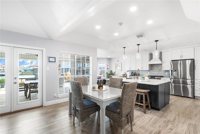 dining space with recessed lighting, visible vents, vaulted ceiling, and light wood finished floors