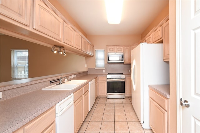 kitchen featuring light brown cabinets, white appliances, sink, and plenty of natural light