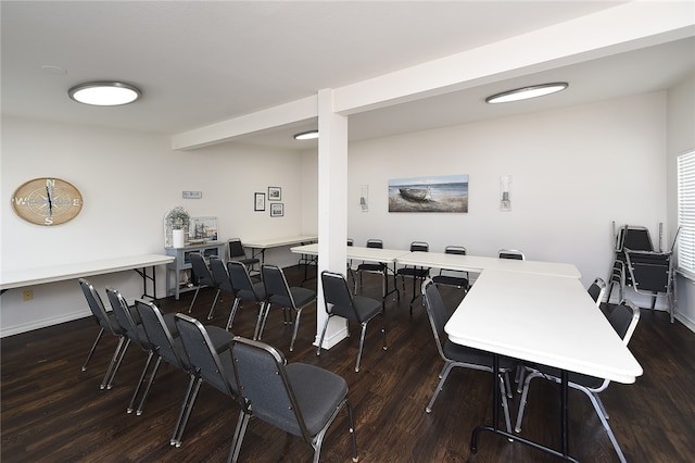 dining area with dark wood-type flooring and beamed ceiling