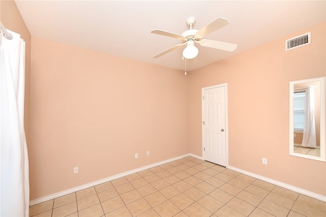 tiled spare room featuring ceiling fan