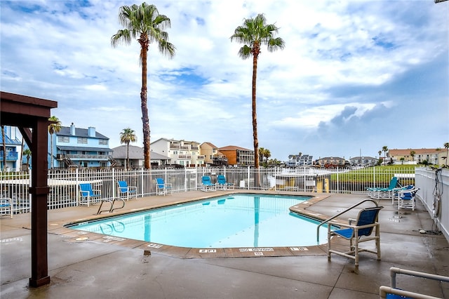 view of pool featuring a patio area and a water view