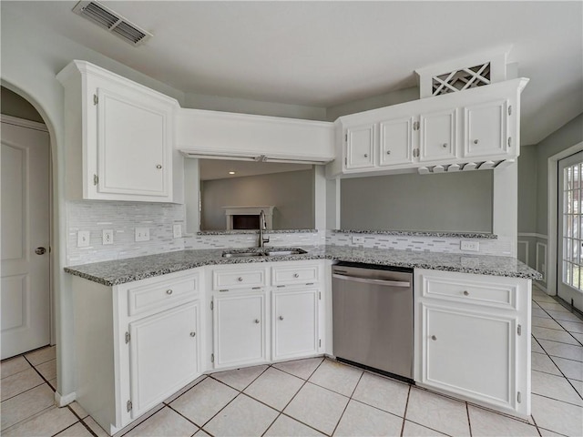 kitchen featuring visible vents, dishwasher, light tile patterned floors, white cabinetry, and a sink