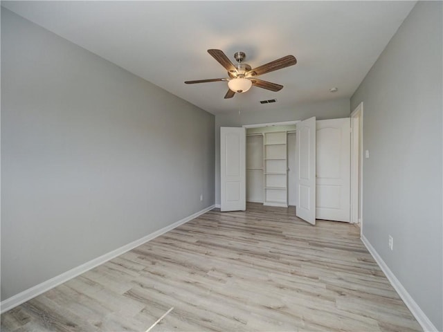 unfurnished bedroom with light wood-type flooring, baseboards, a closet, and visible vents