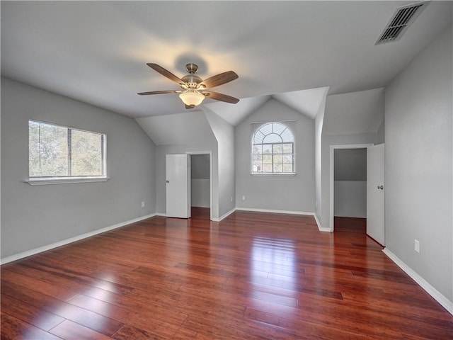 additional living space featuring hardwood / wood-style flooring, a ceiling fan, visible vents, and vaulted ceiling