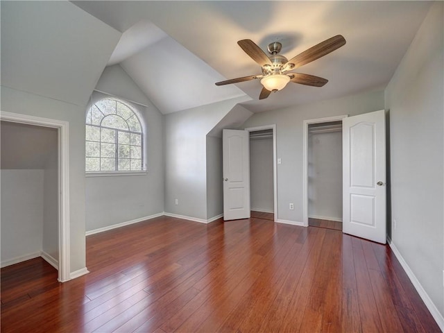 unfurnished bedroom featuring hardwood / wood-style flooring, a ceiling fan, baseboards, and vaulted ceiling