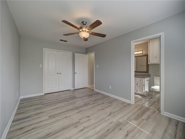 unfurnished bedroom featuring a ceiling fan, light wood-style flooring, baseboards, and a closet