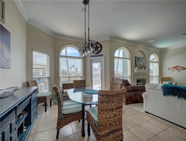 14218 Punta Bonaire Dr, Corpus Christi, TX 78418 - dining room featuring ornamental molding, a chandelier, light tile patterned floors, and a glass covered fireplace