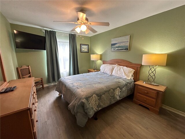 bedroom with ceiling fan and dark wood-type flooring