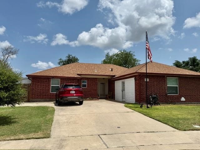 1002 Blue Crest Ln, Beeville, TX 78102 - ranch-style house with brick siding, a front lawn, and driveway