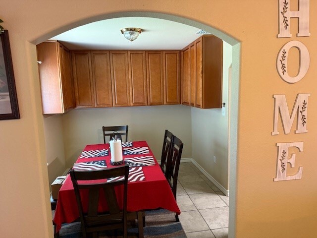 1002 Blue Crest Ln, Beeville, TX 78102 - dining space with arched walkways and light tile patterned floors