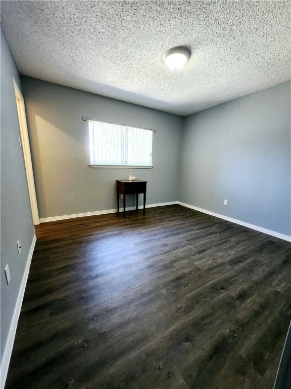 unfurnished room with a textured ceiling and dark hardwood / wood-style floors